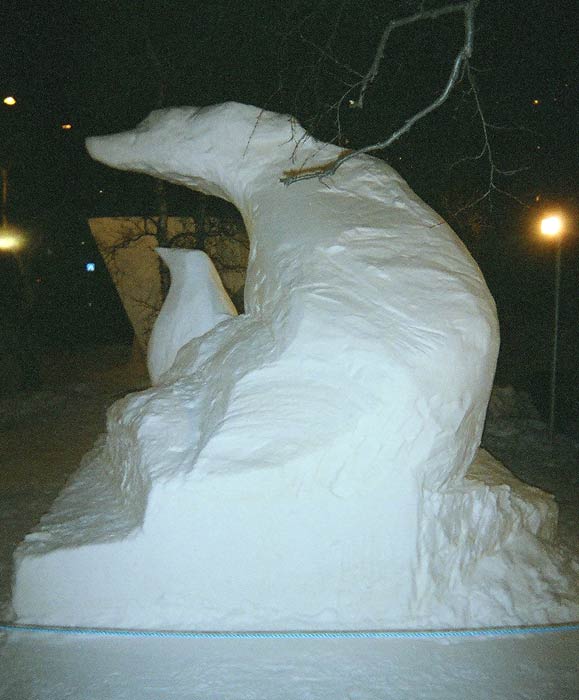 Snöskulptur av pingvin och hund